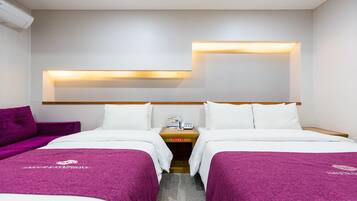 Une chambre d’hôtel avec deux lits, une table de chevet, une lampe et un climatiseur fixé au mur.