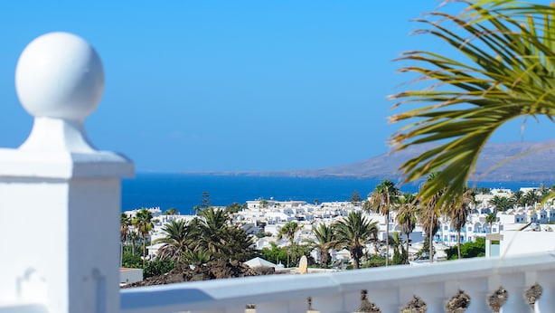 A coastal town with white buildings, palm trees, and a clear blue sky. - Hearth away from house BREIA (Tías)