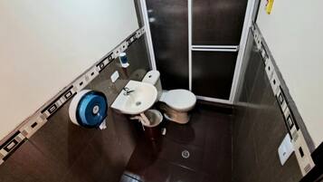 A small bathroom with a toilet, sink, and a blue cleaning machine.