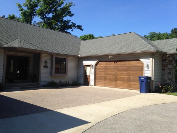 A single-story house with a garage, a front porch, and a driveway. - Well Appointed Apartment with Breathtaking Views (Traverse City)