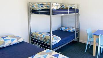 A bunk bed room with a desk and chair.