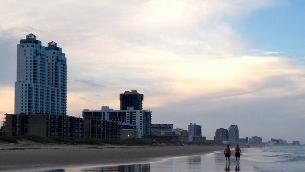 A beach with high-rise buildings in the background.