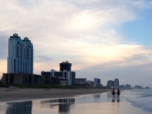 A beach with high-rise buildings in the background.