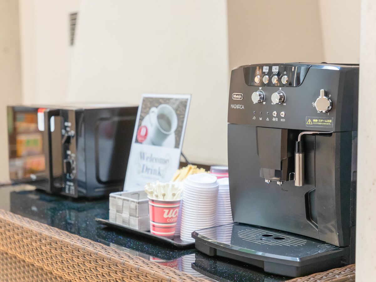 A coffee station with a coffee machine and disposable cups.