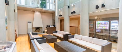 A spacious lobby with high ceilings, modern furnishings, and a vending machine.