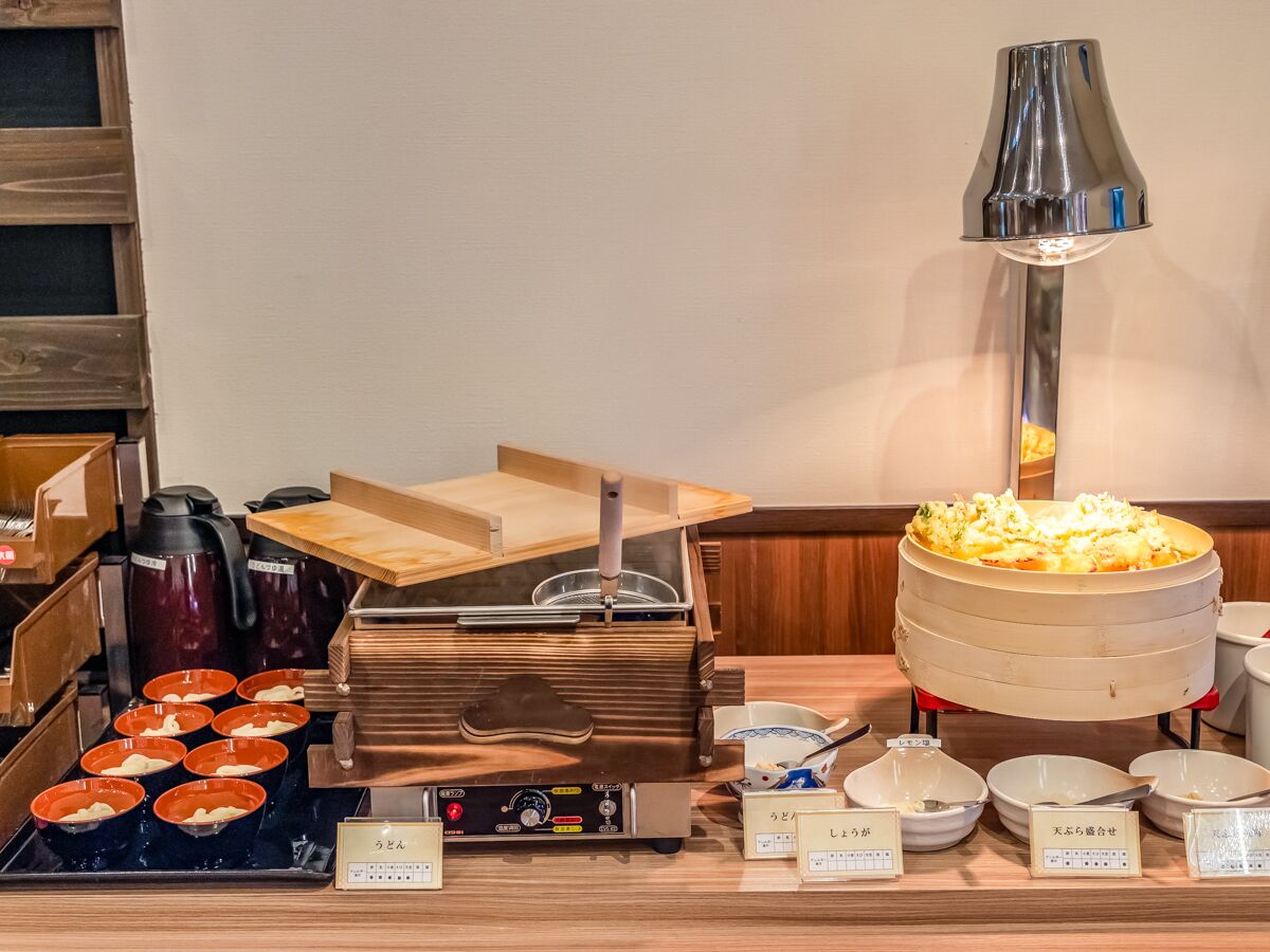 Un buffet proposant divers plats, une machine à café et une lampe.