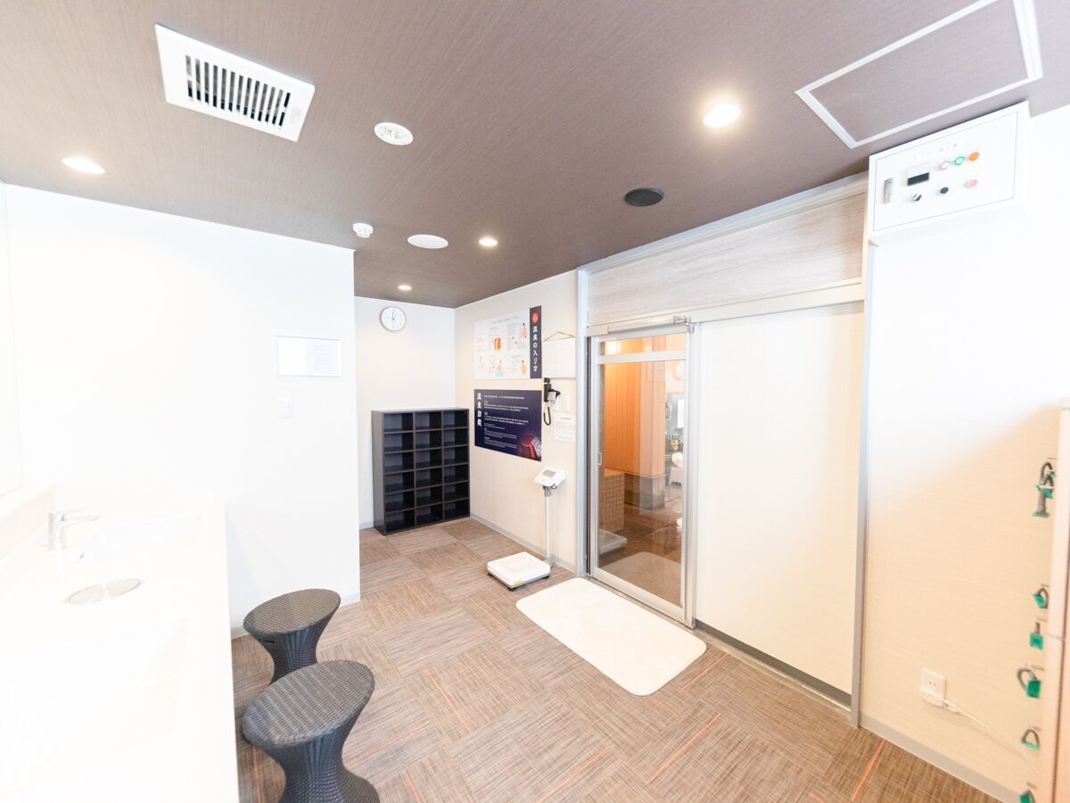 Um interior moderno com um balcão de recepção, uma balança e uma porta de vidro para um banheiro.