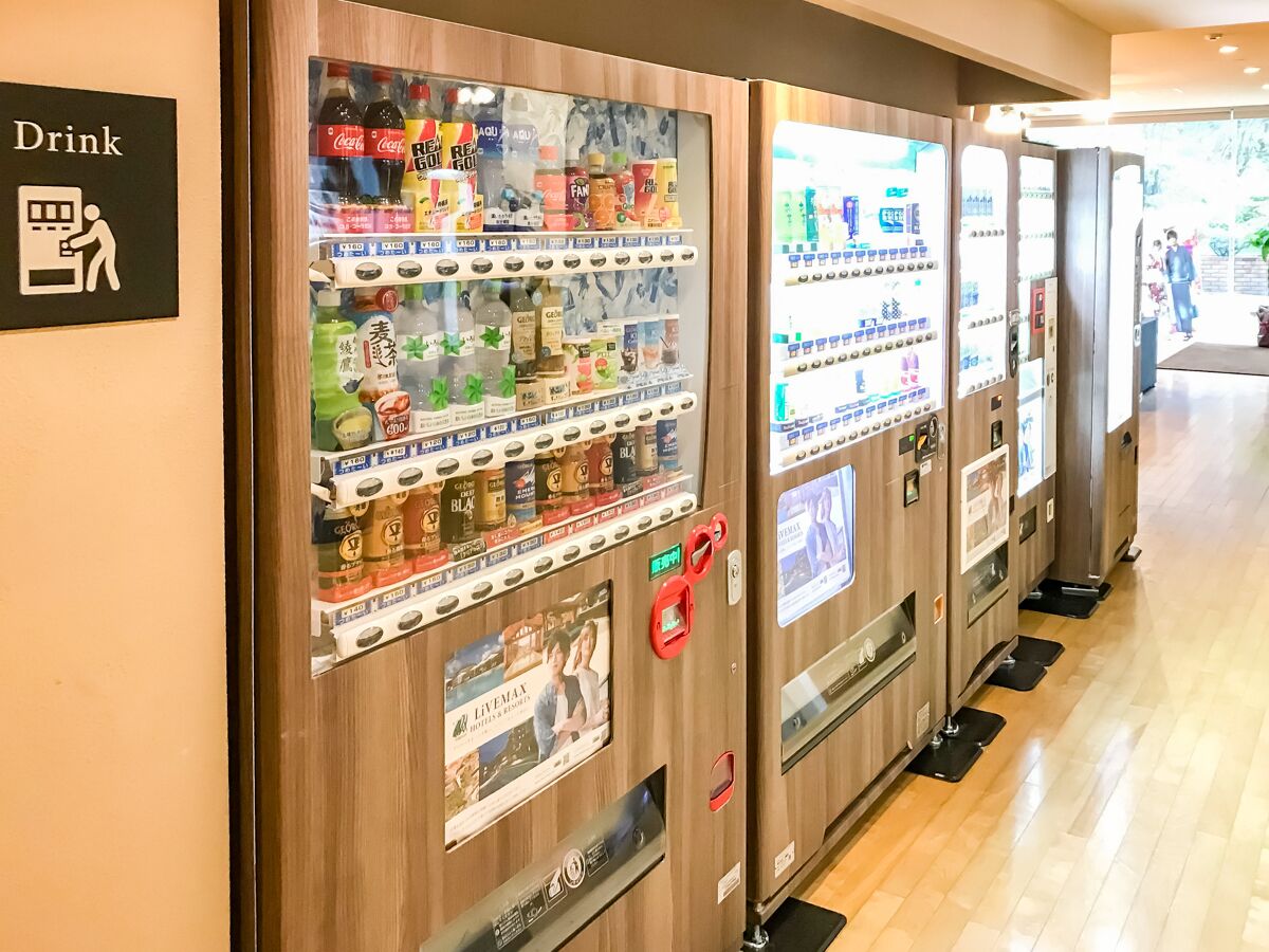 A row of vending machines in a hotel corridor, with a 'Drink' sign on the left.