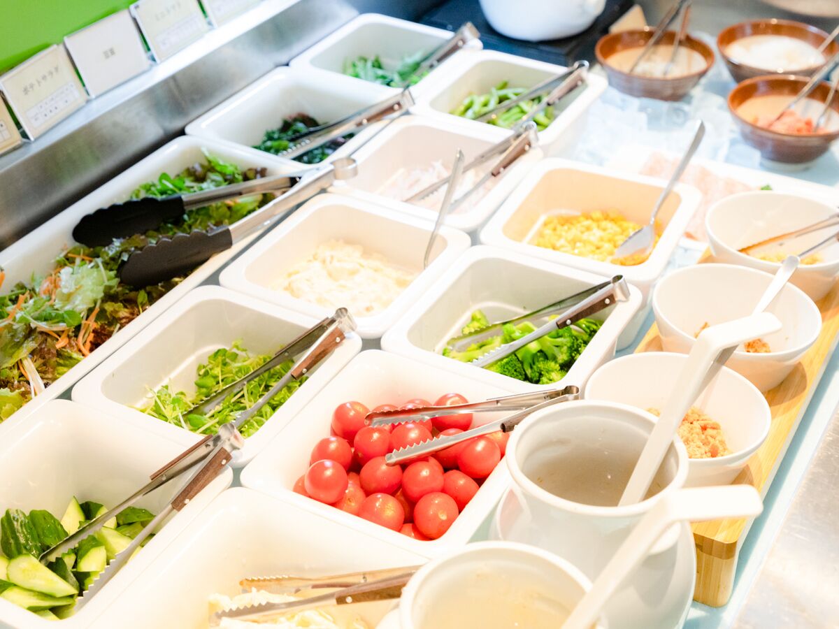A buffet with various food items and utensils.