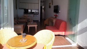 Un espacio habitable compacto con comedor, cocina y un sofá rojo.
