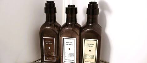 Three bottles of Hajimari Organic products on a metal shelf.