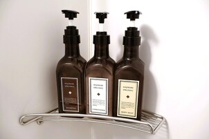 Tres botellas de productos orgánicos Hajimari sobre una estantería metálica.