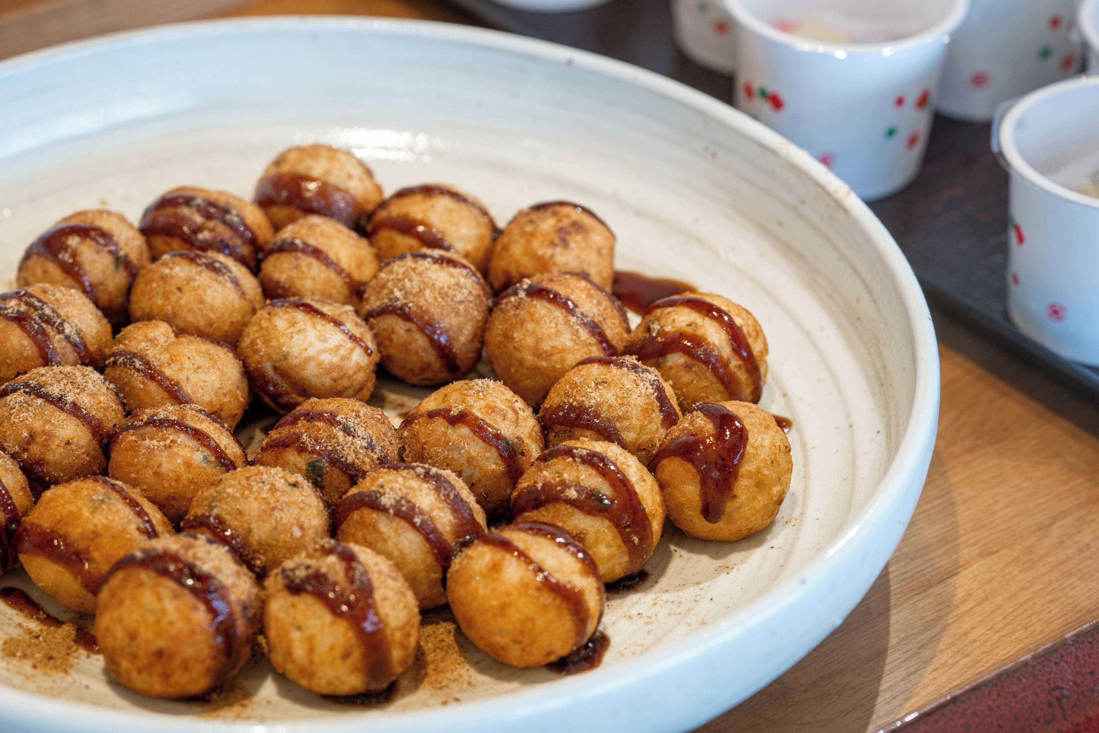 A plate of round, golden-brown food items with a glossy topping, arranged on a white ceramic plate.