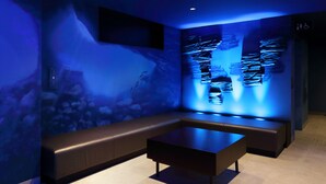 A modern room with a blue-lit wall, a bench, and a table.