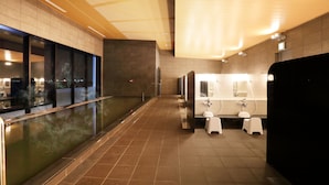 Une salle de bain moderne avec un grand miroir, un plancher chauffant et une vue sur la ville la nuit.