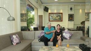 A living room with a sofa, a coffee table, and a refrigerator. - An Hotel Can Tho (Can Tho)