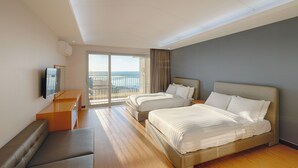 A hotel room with two beds, a seating area, a TV, and a balcony with a view. - Sono Calm Jeju (Seogwipo)