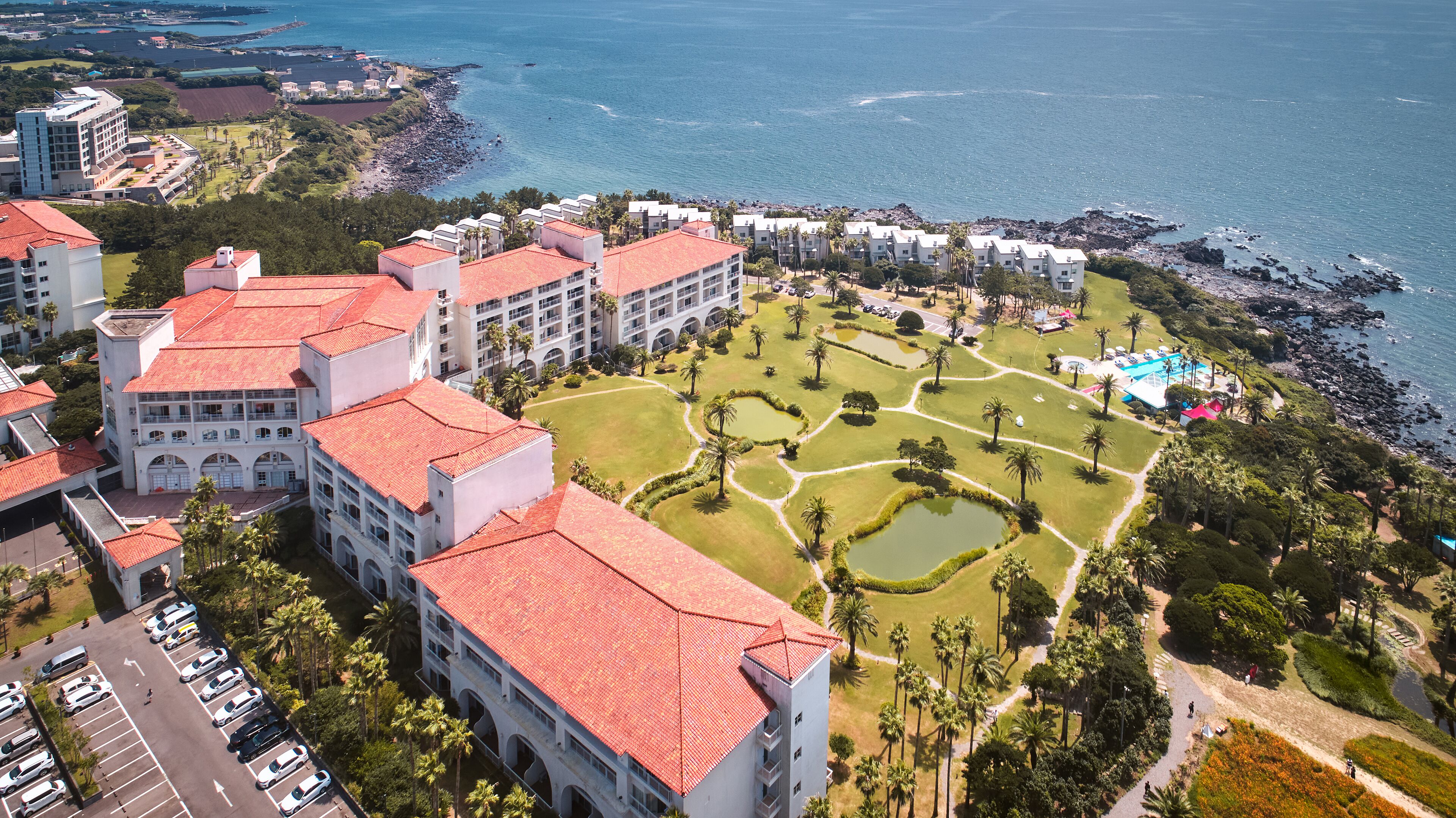 Vista aérea de un resort con varias edificaciones, un campo de golf y una costa.