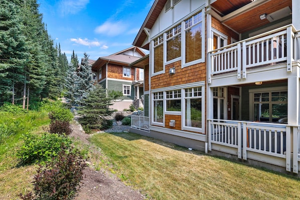 A two-story house with a balcony, surrounded by a forested area. - Incredible ski in/ski out location SX# 37 (EV charger) (Sun Peaks)