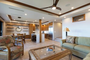 A spacious living area with a dining set, a sofa, and a coffee table. - Exquisite Oceanfront Retreat - Makena Surf F-209 with Stunning Coastal Views! (Makena, Maui)