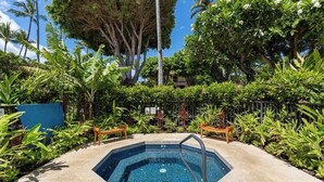 A swimming pool surrounded by lush greenery and palm trees.