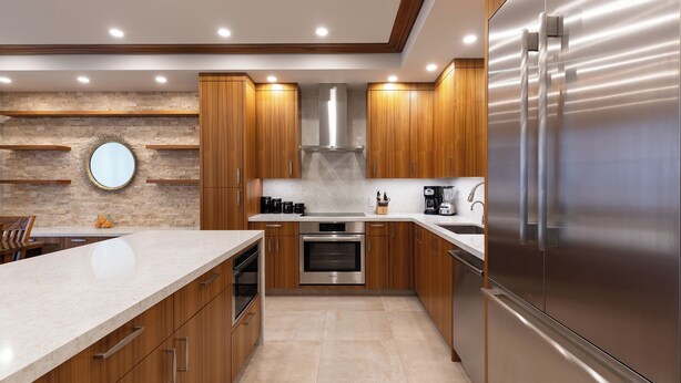 A modern kitchen with wooden cabinets, stainless steel appliances, and a large island.