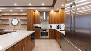 Une cuisine moderne avec des armoires en bois, des appareils en acier inoxydable et un grand îlot central.