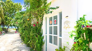 Un bâtiment à la façade blanche, une porte avec une enseigne rouge et blanche, et une fenêtre avec une enseigne rouge et blanche.