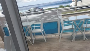 A dining table with plates of food, a drink, and a view of the ocean. - duplex apartment on two floors with panoramic sea views (Le Moule)