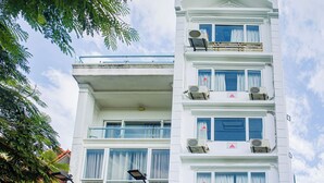 A hotel with a prominent sign, multiple balconies, and a red car parked in front. - Anh Duong Hotel (Hanoi)