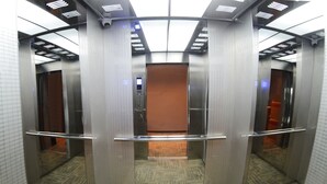 An elevator interior with metallic walls, a control panel, and a patterned floor. - Star Well Hotel (Kuala Lipis)