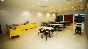 A conference room with tables and chairs, a buffet table, and a red door. - Star Well Hotel (Kuala Lipis)
