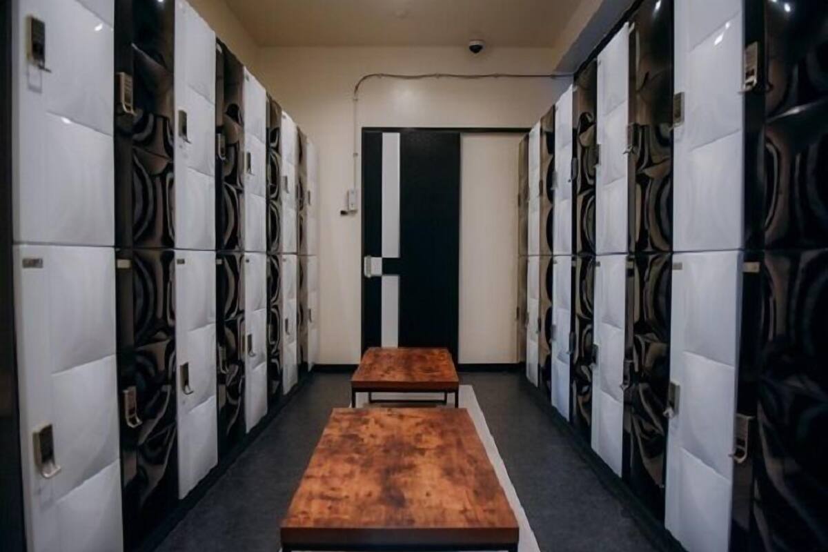 A hallway with lockers on both sides and two wooden benches in the center.