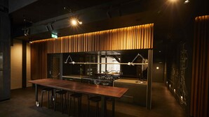 A modern kitchen with a wooden countertop, a built-in stove, and pendant lighting. - Premier Mill Hotel (Katanning)