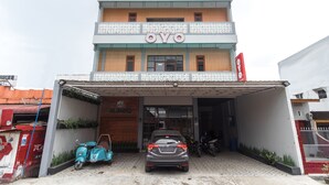 Un bâtiment avec une enseigne indiquant « OYO » et une voiture garée devant.