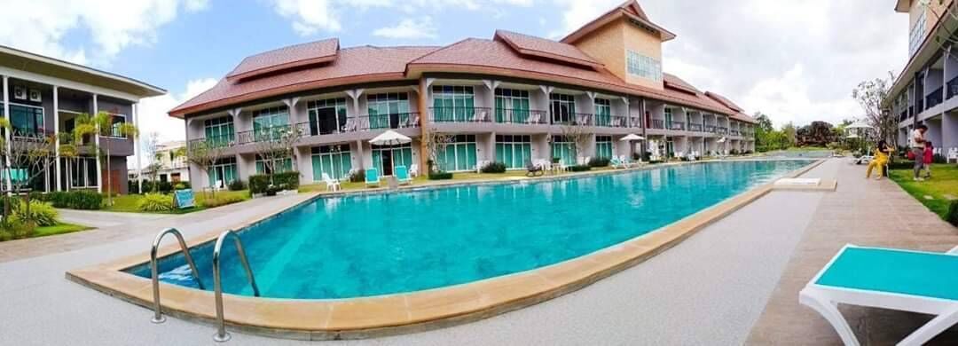A hotel with a large swimming pool, multiple balconies, and a modern architectural design.