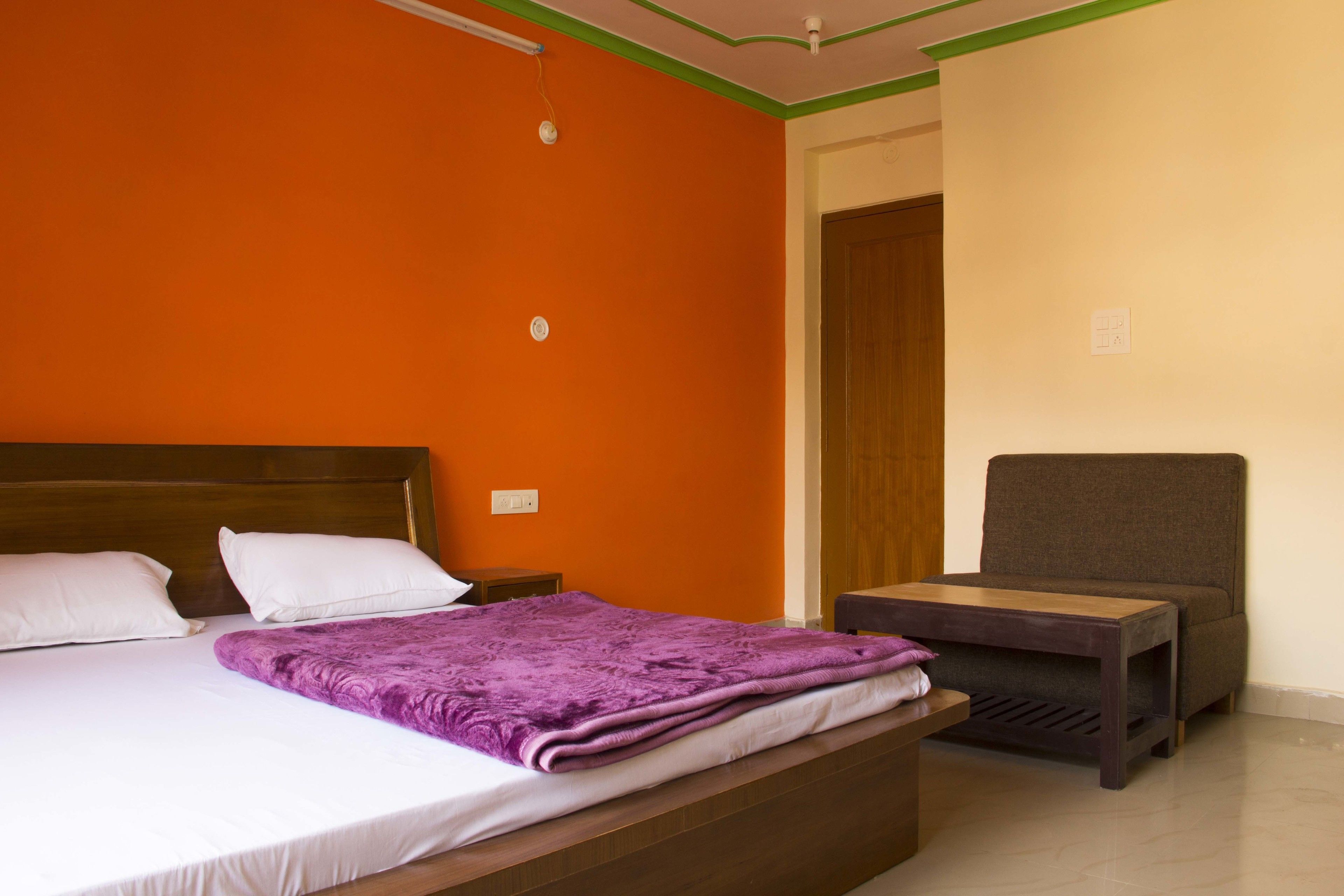 A room with a bed, a small table, and a chair.