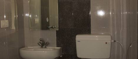 A bathroom with a toilet, sink, and a window above the sink.