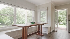 A kitchen with a wooden table, large windows, and a view of the outdoors. - Cherrywood - Luxury retreat - with complimentary EV charging (Exeter)