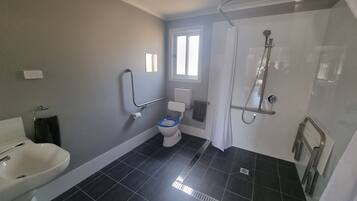 A bathroom with a toilet, bidet, and shower.