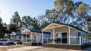 Une rangée de maisons mobiles dotées de vérandas et d’espaces de détente extérieurs.