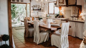 A dining area with a wooden table, chairs, and a chandelier. - Charming house - Montels - Occitanie Mediterranean (Montels)