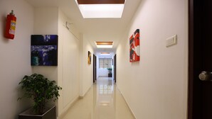 A modern hallway with a fire extinguisher, artwork, and a potted plant. - Park Residency (Kanayannur)