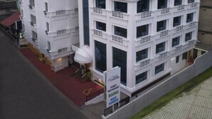A model of a hotel with multiple floors, balconies, and a sign indicating family restaurant rooms and a roof garden. - Park Residency (Kanayannur)