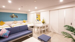 A modern hotel room with two beds, a sofa, a dining table, and a large mirror. - Kariyushi Condominium Resort Miyakojima Fukugistays (Miyakojima)