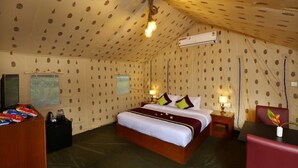 A tent-style room with a bed, bedside tables, a desk, and an air conditioning unit. - Shady Shores (Kanayannur)