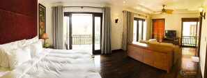 Relax in this stylish room with a large bed, wooden bench, and balcony offering a view of the outside.