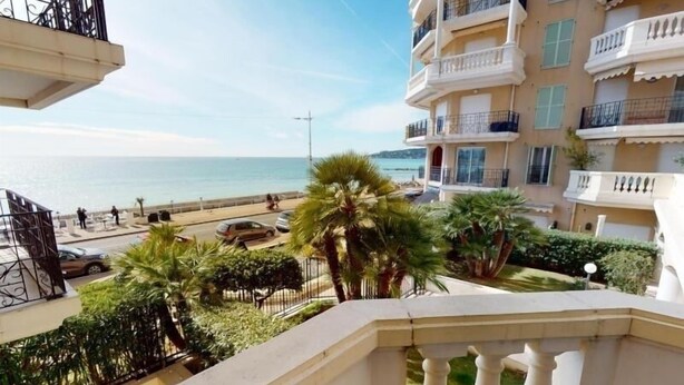 Un balcone con vista sulla spiaggia e un edificio a più piani con balconi.
