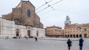 Ein großer, offener Platz mit historischen Gebäuden, darunter eine markante Kirche mit einem hohen Glockenturm.