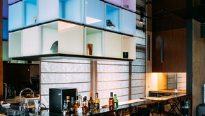 A modern bar area with a unique geometric shelving design, a bar counter, and seating arrangements. - Tsang Kuo Resort (Wujie)